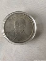 Obverse side of the coin showing the portrait of a man in military attire surrounded by Chinese characters.