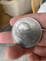 Front side of the coin featuring Winston Churchill wearing a hat with 'Winston Churchill' inscription.
