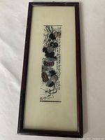 Front view of framed rectangular Chinese art with calligraphy and abstract floral ink design.