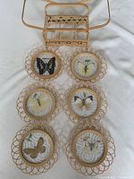 All six butterfly frames arranged with bamboo basket on white surface