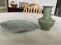 Photo showing the celadon glazed porcelain vase and matching plate placed side by side on a white surface.