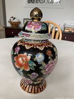 Front view of the ginger jar showing floral design and gold finial