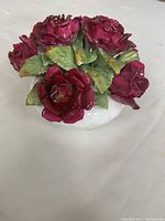Handcrafted bone china flower basket with detailed red roses and green leaves, white basket base