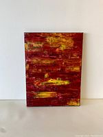 Front view of unsigned abstract acrylic painting featuring red and yellow tones with textured brushwork.