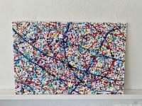 Front view of the canvas placed against a white textured wall showing full artwork.