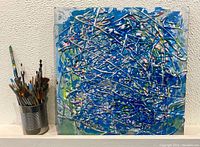 Front view of the square abstract acrylic painting showing layered blue and white paint drips on canvas.