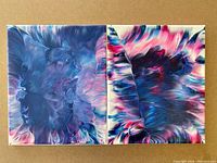 Two original abstract acrylic paintings side-by-side on wall, showing vibrant blues, purples, pinks, and whites with fluid abstract design.