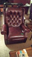 Front view of tufted back dark brown leather recliner chair with cushioned seat.