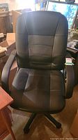Front view of the black office chair showing padded seat, backrest and armrests
