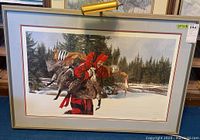 Full view of the framed print depicting a person carrying geese in a snowy forest setting