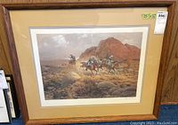 Full view of framed western-themed art print depicting three cowboys on horses galloping in rocky terrain with matte and wood frame.