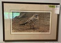 Framed limited edition art print showing the bird and background crab claws with visible frame and matting.
