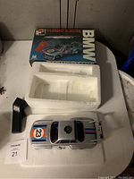 Photo of BMW Turbo 3.0 CSL remote control car with original packaging and styrofoam insert on a white table.