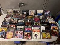 Overview of the multiple CDs spread on a table showing front album covers and case conditions