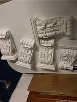 Decorative carved white brackets showing leaf design.