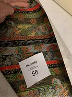 Close-up of the multicolored rice paper print showing floral and geometric designs in red, green, black, gold, and blue colors