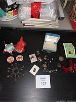 Overview of entire lot on a black desk including all pins, coins, figurines, and box