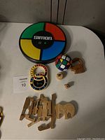 Simon Says electronic game and various wooden puzzles displayed on white table