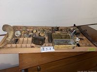 Wide view of wood rack showing multiple compartments filled with various small items including the cow bell, small tins and ceramic figurines.