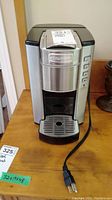 Front view of Cuisinart coffee maker showing stainless steel panel, control buttons on the right side, front drip tray, power cord.