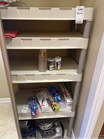Plastic shelving unit with items on shelves to show scale and arrangement. Shelving is white plastic with gray legs and has four shelves.