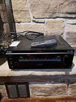 Sony DA30ES digital cinema sound processor with remote on top, front view showing buttons and digital display