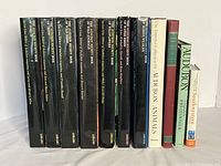 All eleven books arranged upright showing spines and variety of bindings