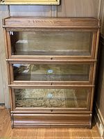 Full front view showing four stacked bookcase sections with glass drop-front doors