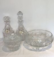 All crystal items arranged, showing the salad bowl, covered sugar bowl, and two decanters with metal labels for Scotch and Sherry.