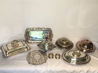 Full lot of vintage silver plated serving items displayed together, showing trays, covered dishes, and salt/pepper shakers.
