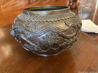 Front angle showing serpent figures and floral motifs on bowl exterior