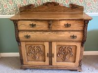 Front view of vintage oak buffet showing carved decorative details and hardware