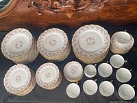 Wide view of stacked plates, bowls, saucers and arranged teacups