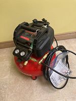 Front and side view of the Craftsman air compressor showing brand label, gauges, and red tank.