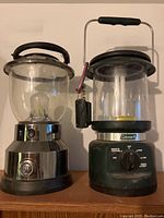 Two battery-operated lanterns, one GE and one Coleman with remote control
