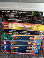 Photo of DVDs including The Outer Limits Volume 1-3, Jillian Michaels workout, Star Trek 3-movie collection, Superman Adventures 4 volumes, Groundhog Day.