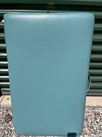 Blue vinyl folding massage table folded in half, showing full length and smooth surface.