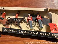 Photo showing handpainted metal toy soldiers and horses in original box with label