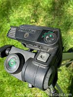 Close-up photo of the Slik 88 tripod head showing tilt dial, bubble level, and locking mechanism.