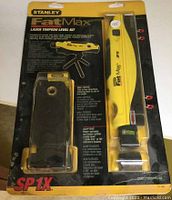 Full view of the unopened Stanley FatMax Laser Torpedo Level Kit blister packaging showing laser level in yellow, mini tripod, and other accessories.