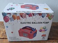 Box front view showing electric balloon pump image and colorful balloon graphics with description and features.