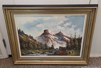 Full view of framed landscape painting showing mountainous scene with river and forest, approximately 35 by 27 inches.