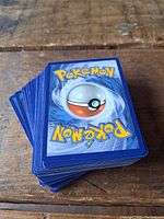 Stack of Pokemon cards showing the blue back with Pokeball design, typical of Pokemon TCG cards.