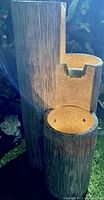 Full view of the modern outdoor water fountain with three circular basins and textured bark-like exterior.