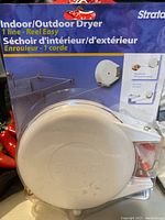 Front view of sealed Strata clothesline reel packaging showing product and branding details.