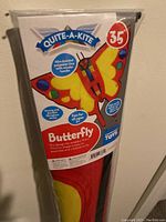 Close-up of package showing the Quite-A-Kite Butterfly kite branding and product features including 35 inch size, 40m braided polyester line with wooden handle, and colorful butterfly design.