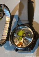 Close-up photo of Tweety Bird watch with gray leather strap and colorful dial graphics.