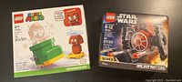 Front view of the LEGO Super Mario Expansion Set 71366 box and the LEGO Star Wars Microfighters Series 5 TIE Fighter 75194 box, both sealed.