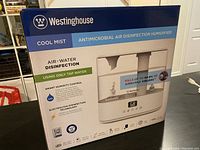 Closed box showing Westinghouse branding and features including cool mist, antimicrobial air disinfection, smart humidity control, electrolysis disinfection technology, and digital display.
