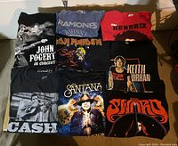 Photo of nine rock band T-shirts including John Fogerty, Ramones, Iron Maiden, Jimi Hendrix, Keith Urban, Johnny Cash, Santana, The Doors, and Lynyrd Skynyrd.